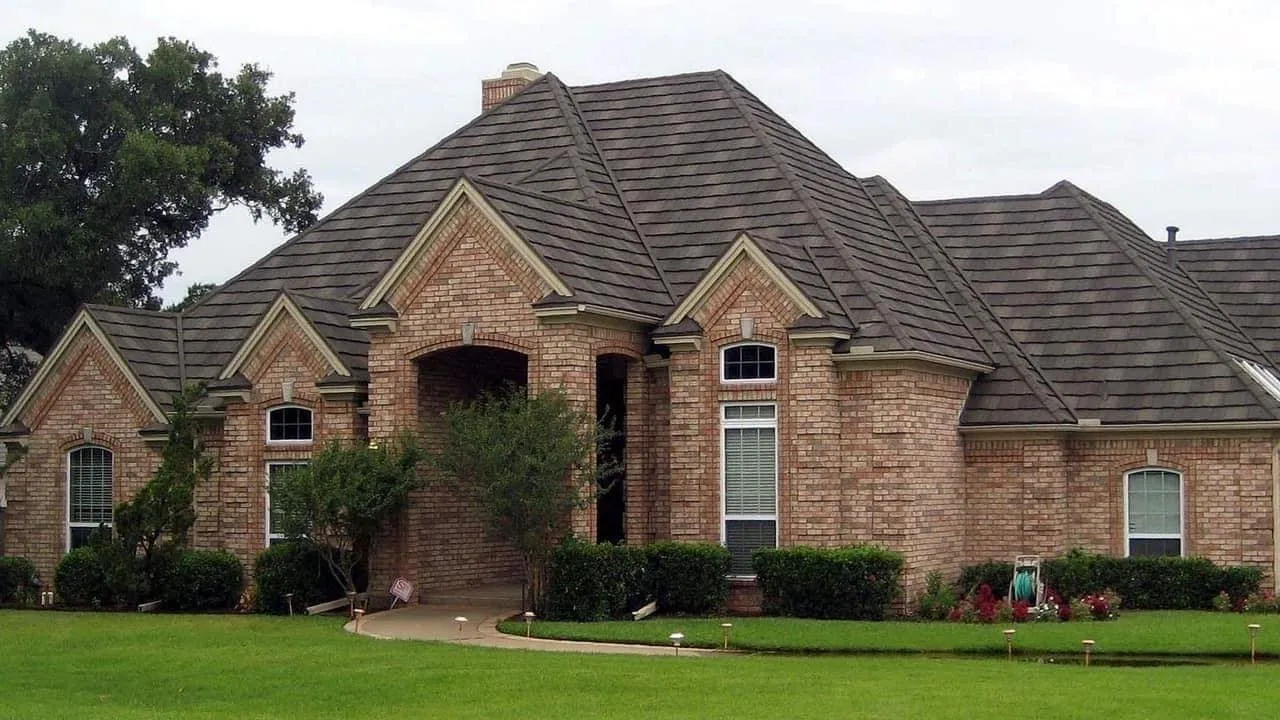A brick house with gray metal shingles. Rhino Roofing and Windows offers roofing services - including metal shingle installation - to Indiana and most of Ohio and Michigan.
